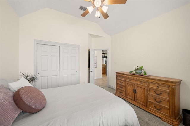 bedroom with vaulted ceiling, light carpet, a closet, and a ceiling fan