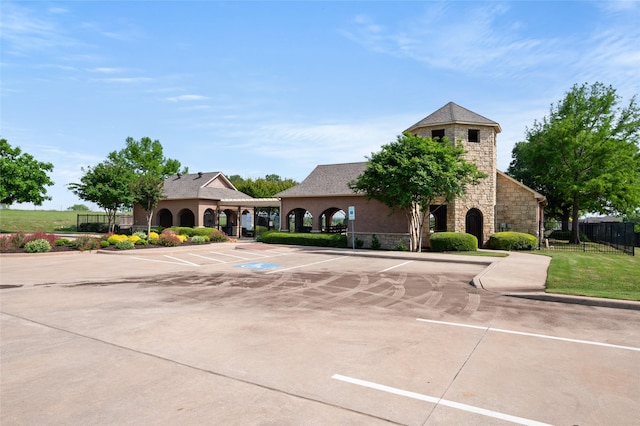 view of property with uncovered parking and fence