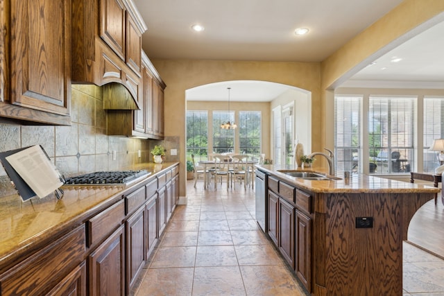 5403 Englenook Dr, Parker, TX 75002 - kitchen with light stone countertops, a sink, arched walkways, stainless steel appliances, and tasteful backsplash