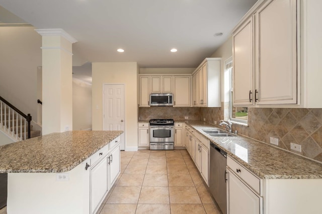 kitchen featuring a sink, appliances with stainless steel finishes, decorative backsplash, and light stone counters