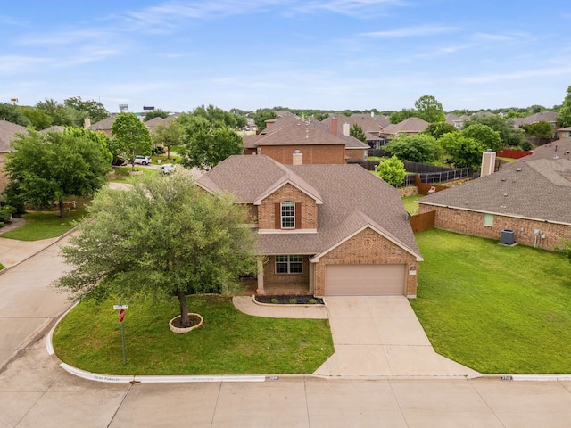 traditional-style home with a front yard, brick siding, concrete driveway, an attached garage, and a residential view