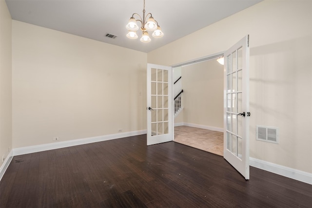 2719 Foxpoint Trl, Arlington, TX 76017 - spare room with french doors, a chandelier, wood finished floors, and baseboards