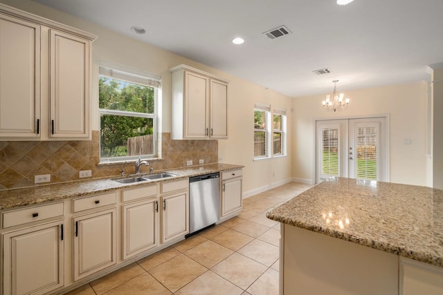 kitchen with backsplash, visible vents, dishwasher, a sink, and cream cabinetry