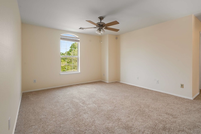 carpeted empty room featuring baseboards and a ceiling fan