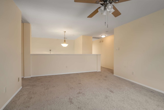 carpeted empty room featuring a ceiling fan, baseboards, and visible vents