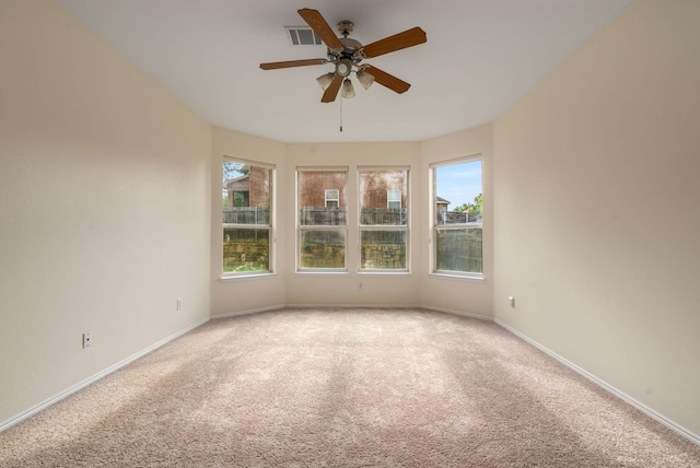 spare room featuring visible vents, carpet, ceiling fan, and baseboards