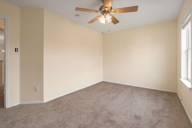carpeted empty room featuring baseboards and ceiling fan
