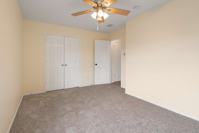 unfurnished bedroom featuring carpet floors, baseboards, ceiling fan, and a closet