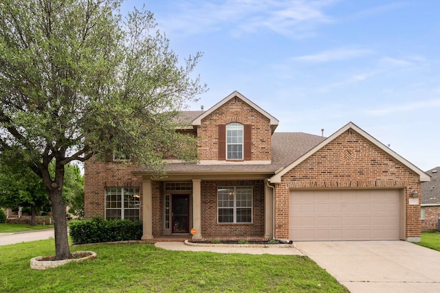 traditional-style home with a front lawn, roof with shingles, brick siding, an attached garage, and driveway