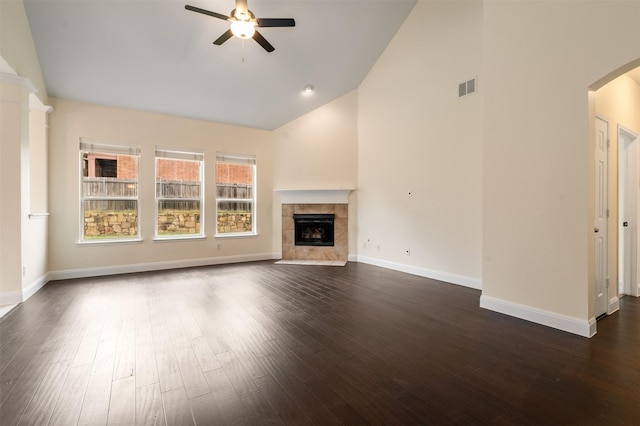 2719 Foxpoint Trl, Arlington, TX 76017 - unfurnished living room with a ceiling fan, arched walkways, dark wood-style flooring, a tile fireplace, and baseboards