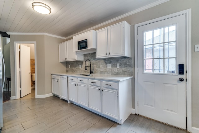 kitchen featuring a sink, white cabinetry, paneled dishwasher, and light countertops