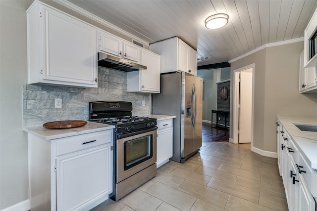 kitchen with under cabinet range hood, stainless steel appliances, white cabinetry, and tasteful backsplash