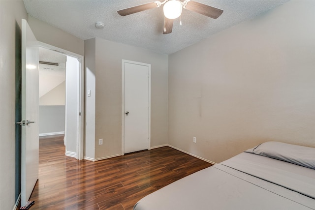 bedroom featuring a textured ceiling, baseboards, a ceiling fan, and wood finished floors