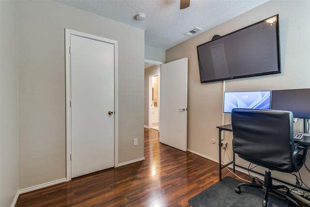 office featuring baseboards, a textured ceiling, visible vents, and wood finished floors