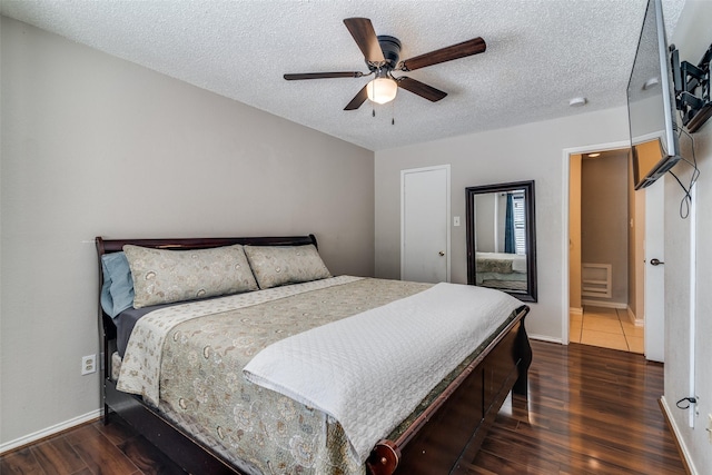 bedroom with baseboards, a ceiling fan, a textured ceiling, and wood finished floors