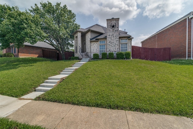 view of front of home featuring brick siding, fence, a chimney, and a front lawn