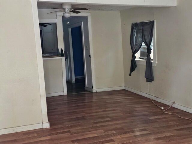 spare room with dark wood-style flooring, ceiling fan, baseboards, and cooling unit