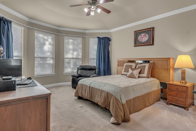 bedroom featuring ceiling fan, light colored carpet, ornamental molding, and a tray ceiling