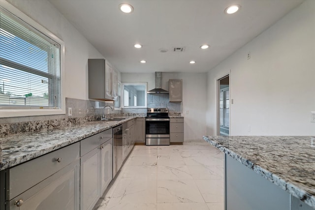 kitchen with recessed lighting, stainless steel electric stove, a sink, and wall chimney exhaust hood