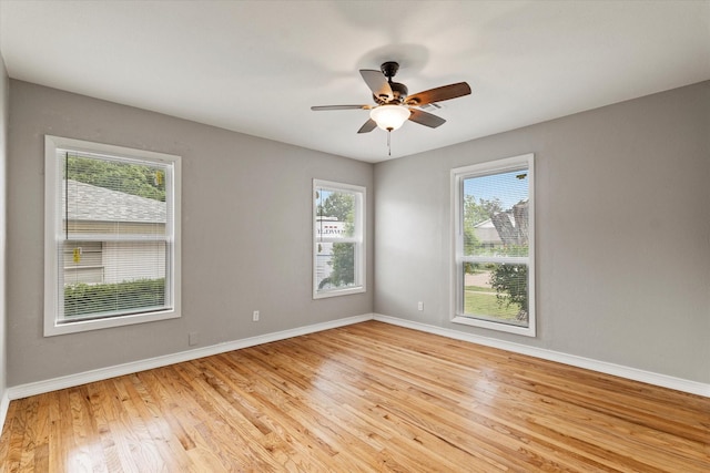 empty room featuring baseboards, ceiling fan, and light wood-style flooring