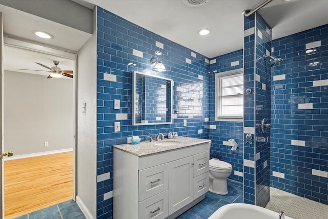 full bathroom featuring a ceiling fan, tile walls, tile patterned flooring, vanity, and tiled shower