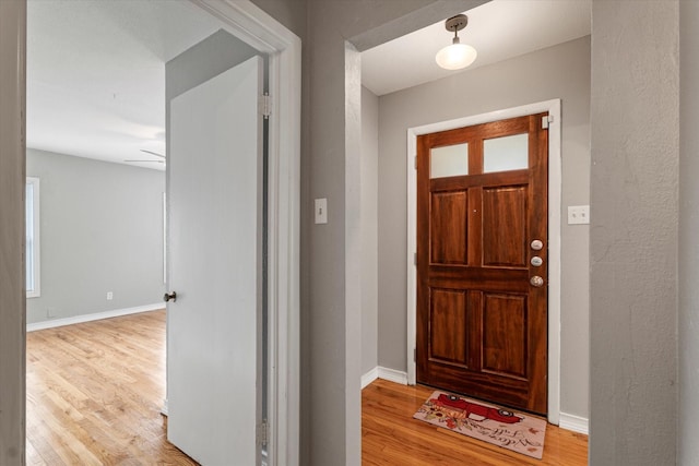 entryway with baseboards and wood finished floors