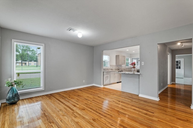 unfurnished living room featuring baseboards, light wood-style flooring, and visible vents