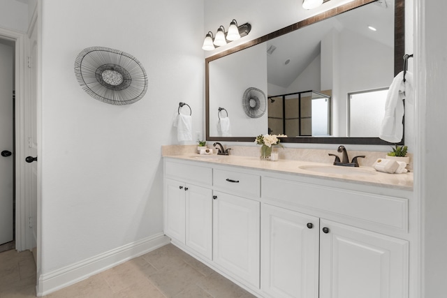 bathroom featuring a sink, vaulted ceiling, a shower stall, and double vanity