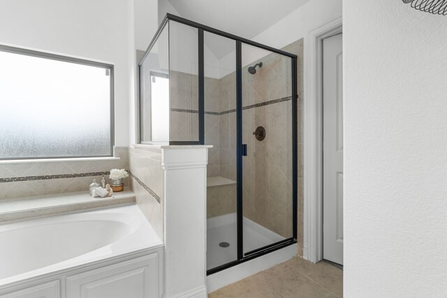 bathroom featuring tile patterned floors, a stall shower, and a bath