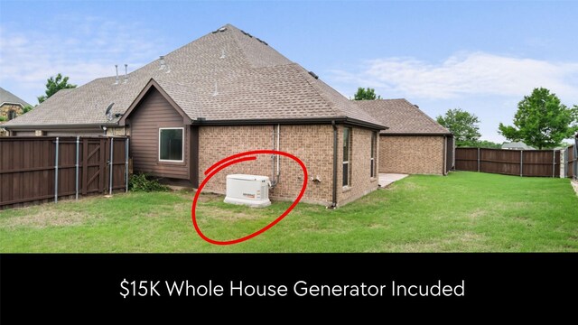 back of property featuring a fenced backyard, a shingled roof, a yard, and brick siding