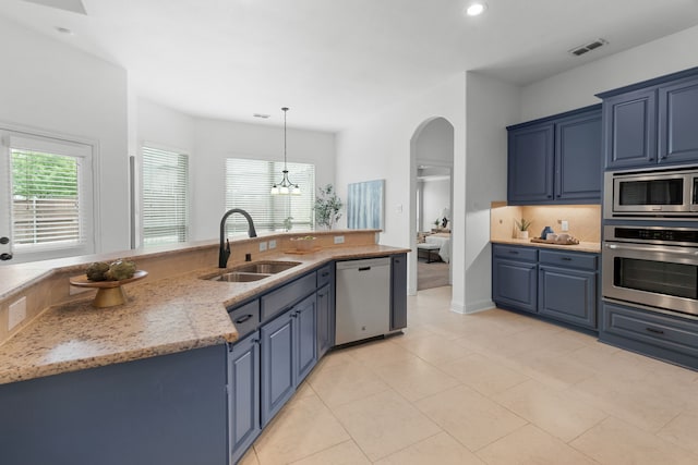 kitchen featuring blue cabinets, appliances with stainless steel finishes, arched walkways, a sink, and recessed lighting