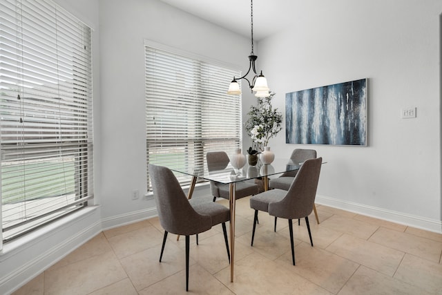 dining room featuring baseboards, a notable chandelier, and light tile patterned floors