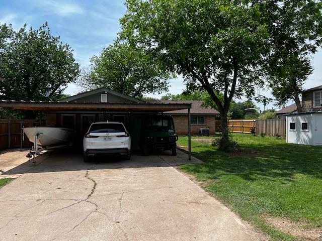 view of front of house with fence, driveway, and a front lawn