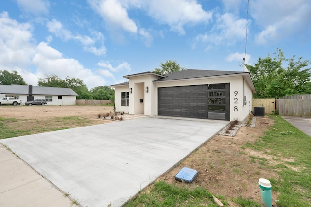 928 College St, Sulphur Springs, TX 75482 - prairie-style home with fence, cooling unit, concrete driveway, an attached garage, and stucco siding