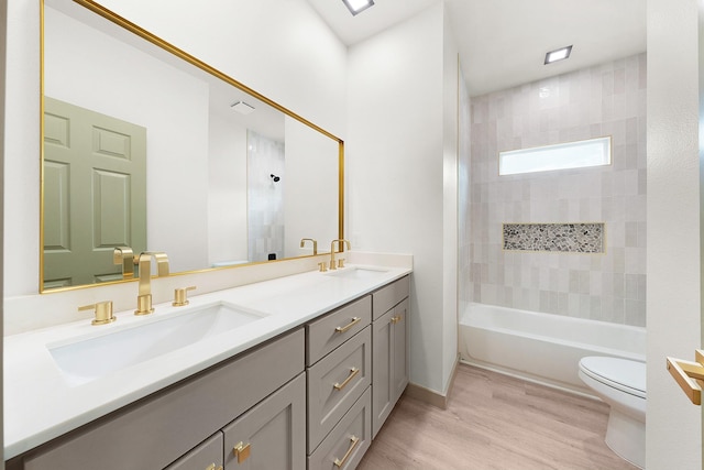 928 College St, Sulphur Springs, TX 75482 - bathroom featuring double vanity, toilet, a sink, and wood finished floors