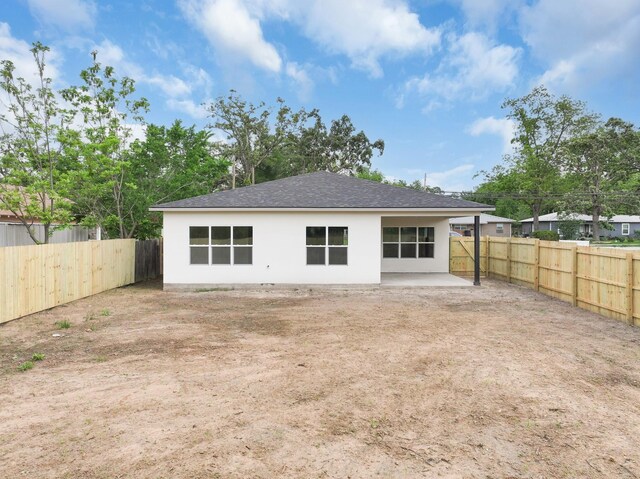 928 College St, Sulphur Springs, TX 75482 - rear view of property featuring roof with shingles, a fenced backyard, a patio area, and stucco siding