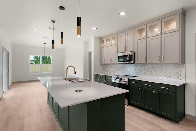 928 College St, Sulphur Springs, TX 75482 - kitchen featuring a sink, light wood finished floors, light countertops, stainless steel appliances, and decorative backsplash