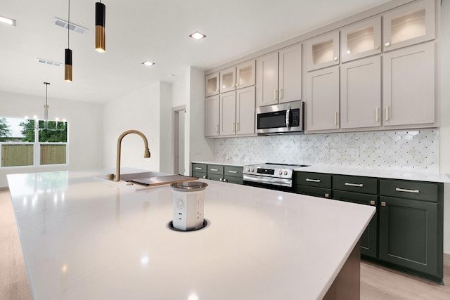 928 College St, Sulphur Springs, TX 75482 - kitchen featuring visible vents, light countertops, appliances with stainless steel finishes, and backsplash