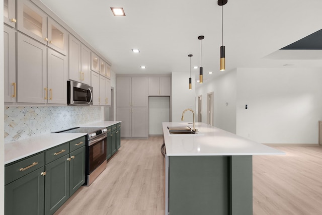 928 College St, Sulphur Springs, TX 75482 - kitchen with light wood-style floors, a sink, green cabinetry, and stainless steel appliances