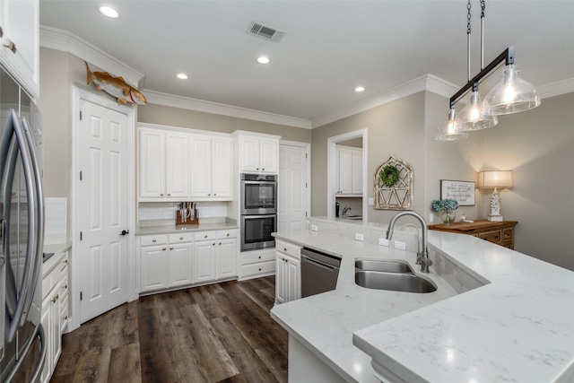 kitchen with a large island, visible vents, a sink, ornamental molding, and stainless steel appliances