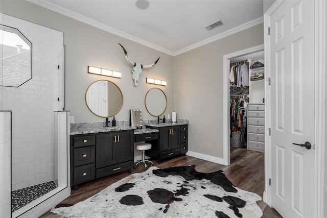 full bath with visible vents, crown molding, wood finished floors, vanity, and a walk in shower