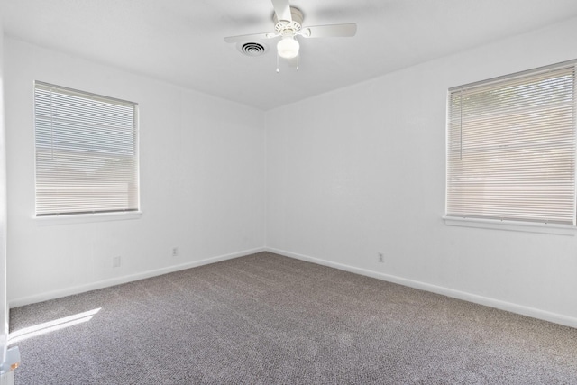 empty room with baseboards, plenty of natural light, carpet flooring, and visible vents