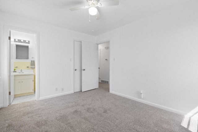 unfurnished bedroom featuring visible vents, a sink, baseboards, and light carpet