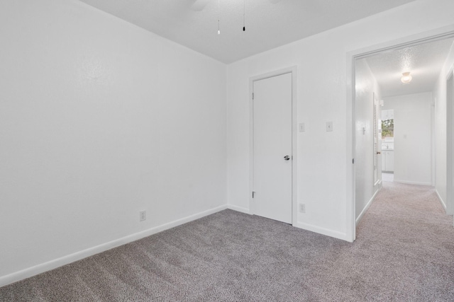 unfurnished bedroom featuring baseboards, a ceiling fan, and carpet