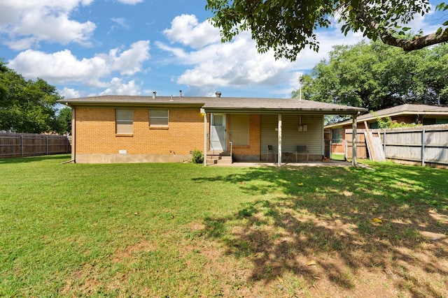 back of property featuring a fenced backyard, a patio, a lawn, and brick siding