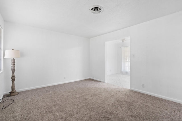 empty room with visible vents, carpet, and baseboards