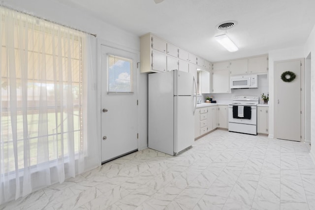 kitchen with visible vents, light countertops, and white appliances