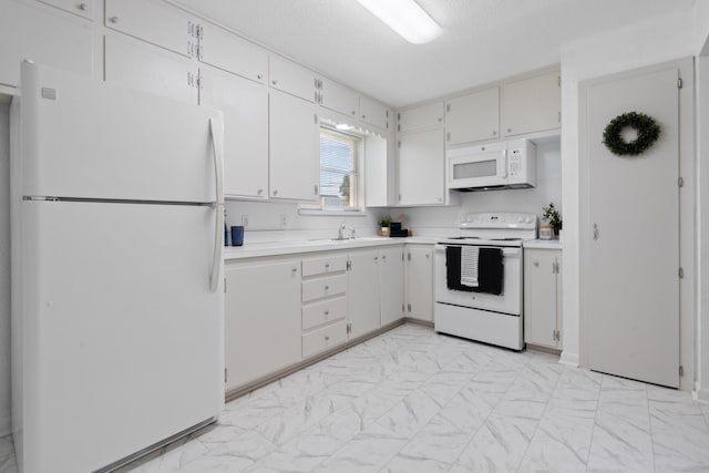 kitchen featuring marble finish floor, white appliances, light countertops, white cabinets, and a sink