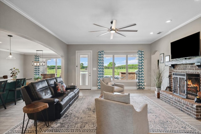 living area featuring a wealth of natural light, ceiling fan, light wood finished floors, and visible vents