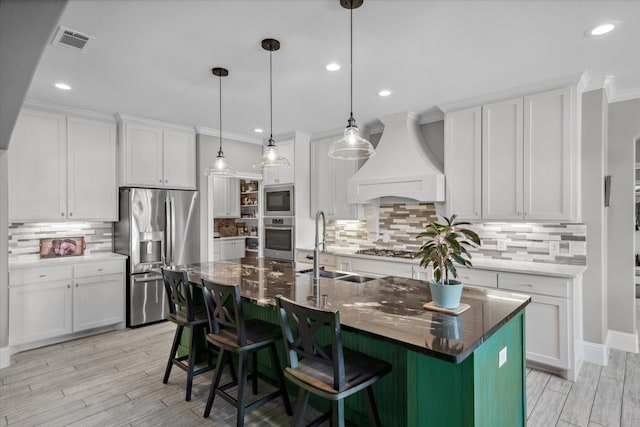 kitchen with tasteful backsplash, custom exhaust hood, stainless steel appliances, and visible vents